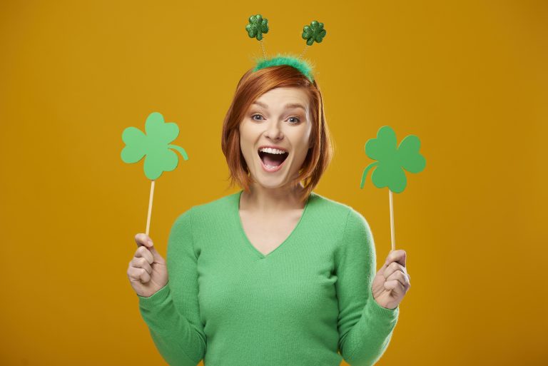 Screaming woman holding clover shaped banner with copy space